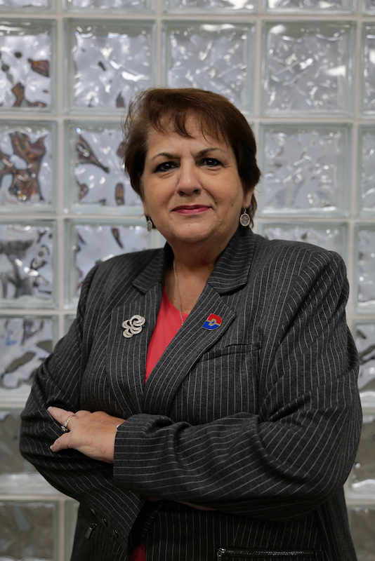 Dr. Madeline Burillo-Hopkins standing with arms crossed.