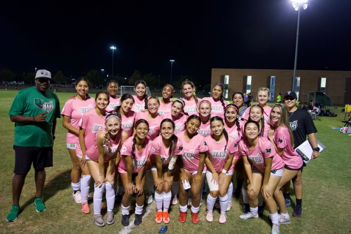 A group of women in pink uniform and coaches.