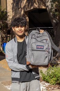 Boy holding a backpack.