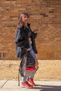 Girl holding a backpack.