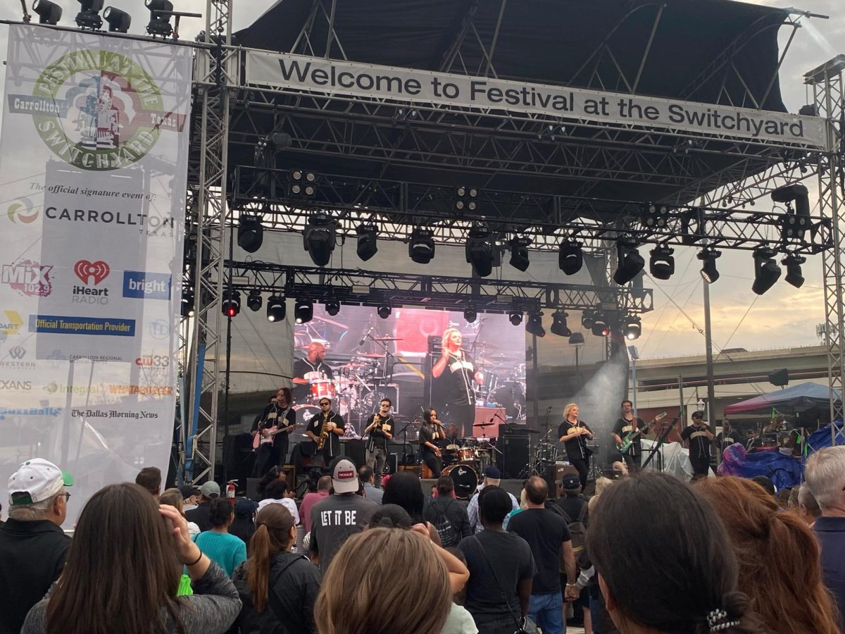 Band performing in a stage in-front of a crowd.