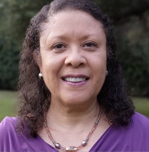 A headshot of a woman wearing purple shirt.