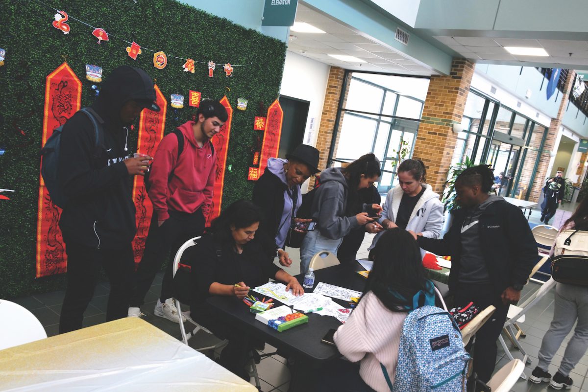 Students gathered around a table with Lunar New Year decorations at the back.