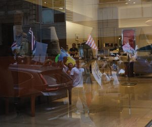 A worker looks out as protestors pass by his place of work. 