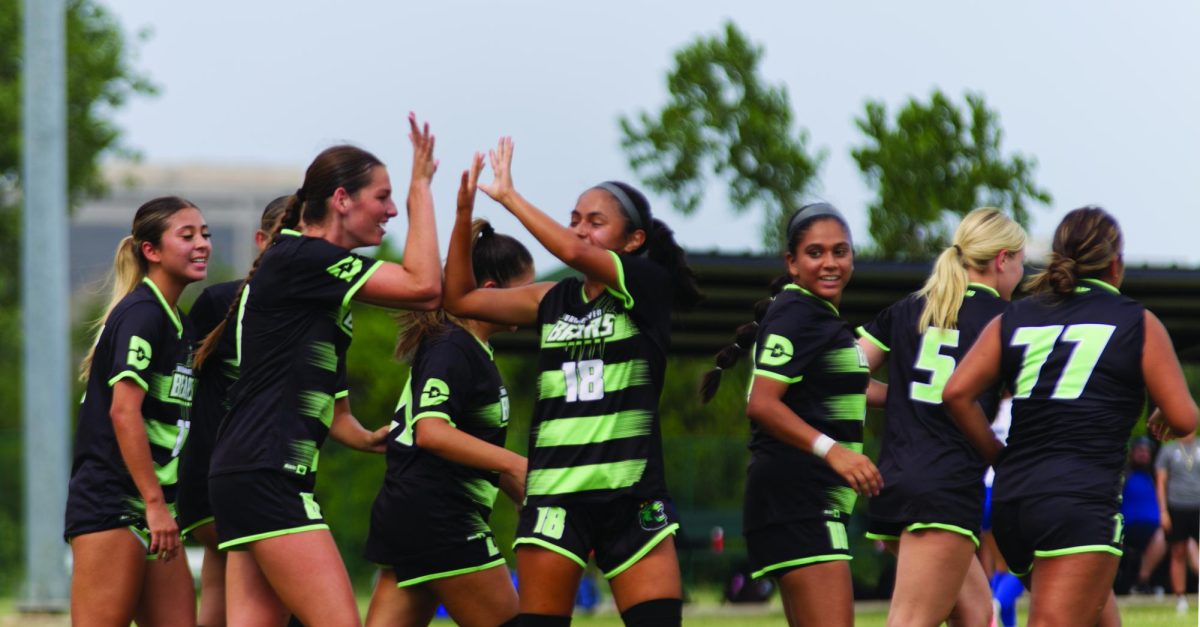 Players Kate Carlson and Ava Little celebrating a goal.