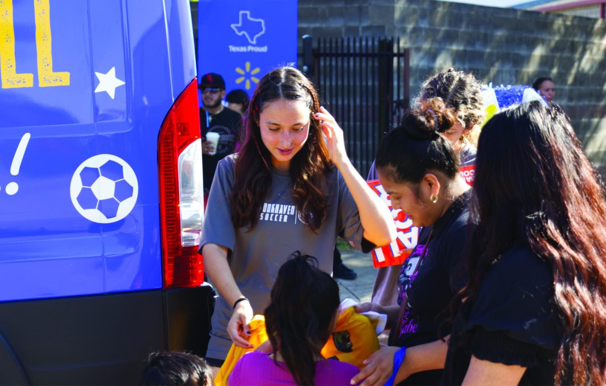 Penelope Doria (24) gives away Brookhaven soccer jersies to students from Saldivar Elementary.