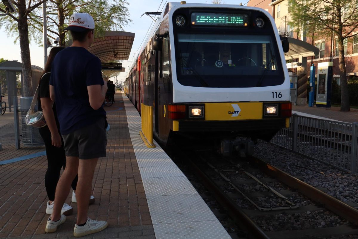 A green line DART train arriving at Farmers Branch station.