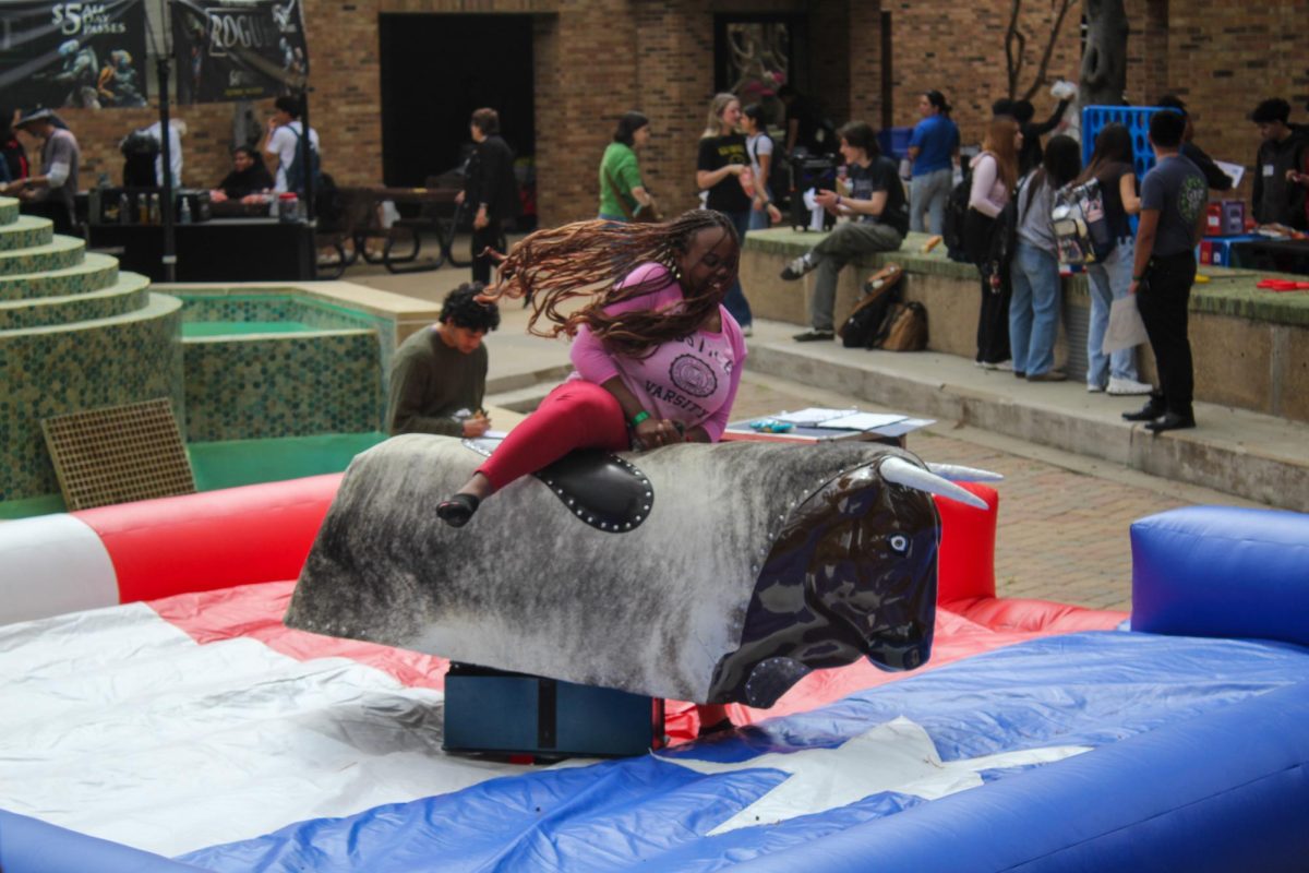 Brookhaven nursing student Paula Obele struggles to stay on the bucking mechanical bull at Spring Fest.